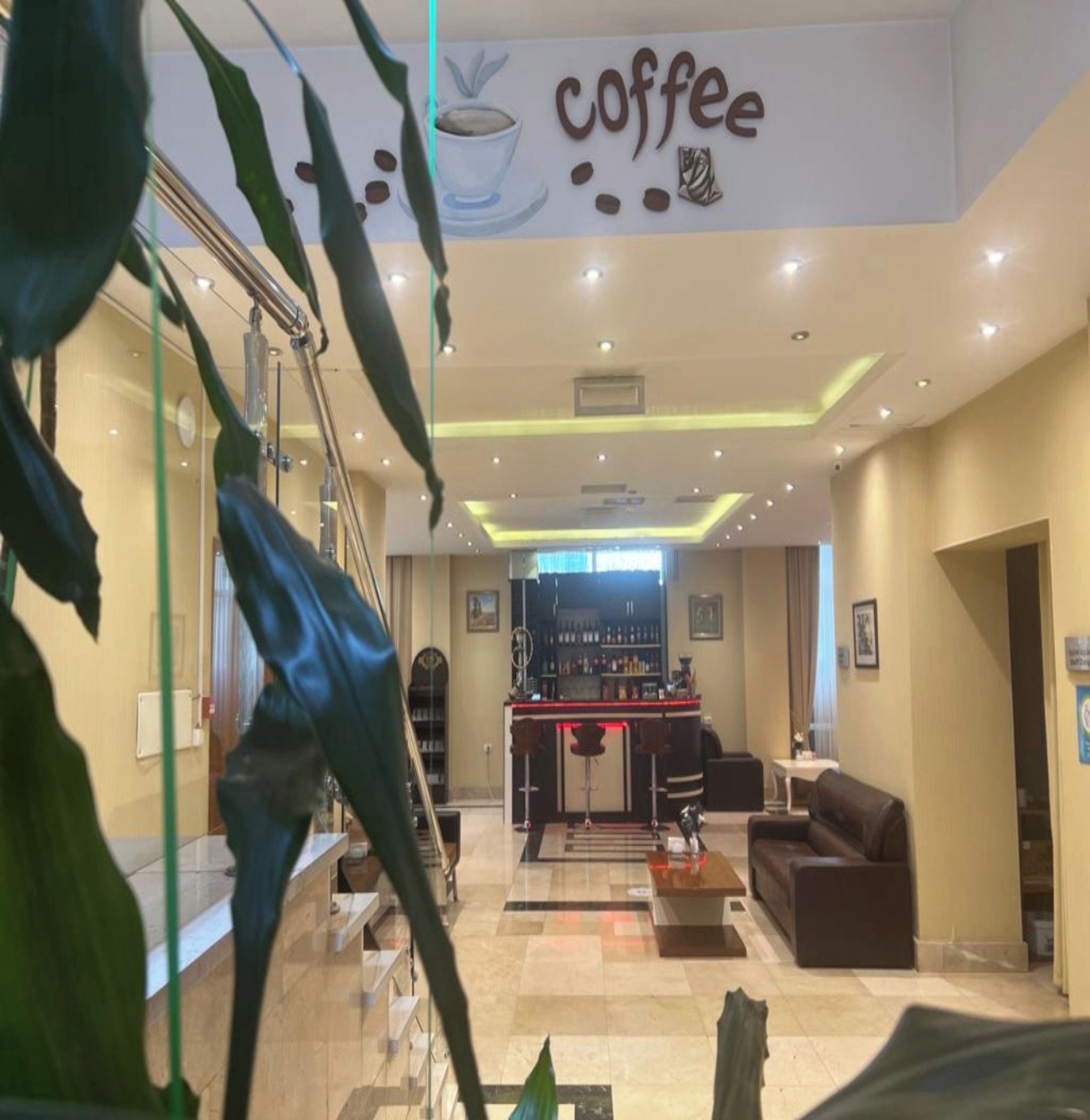 A modern lobby with a coffee bar, seating area, and a staircase.