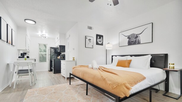 A modern bedroom with a bed, bedside tables, a desk, and a chair. - Hyde Park Gem–Modern Studio Near UT & Downtown (Austin)