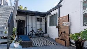A modern outdoor area with a staircase, a bicycle, a relaxation sign, and potted plants.
