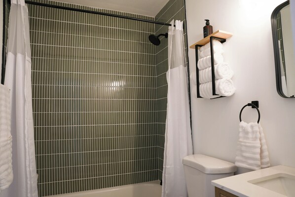 Une salle de bain avec une douche, des toilettes et un lavabo.