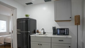 A compact kitchen with a Galanz refrigerator, a microwave, and a sink. - Comfort Living 2BR Deluxe Suite (West Palm Beach)