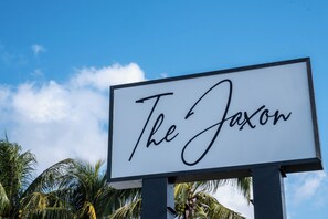 Un letrero con el texto "The Jaxon" sobre un cielo azul despejado.
