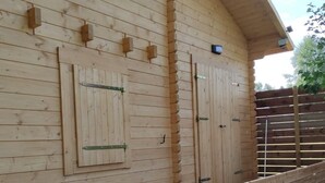 A wooden building with a covered porch and a bench. - Detached chalet with unobstructed view of natural surroundings. (Ville-sur-Lumes)