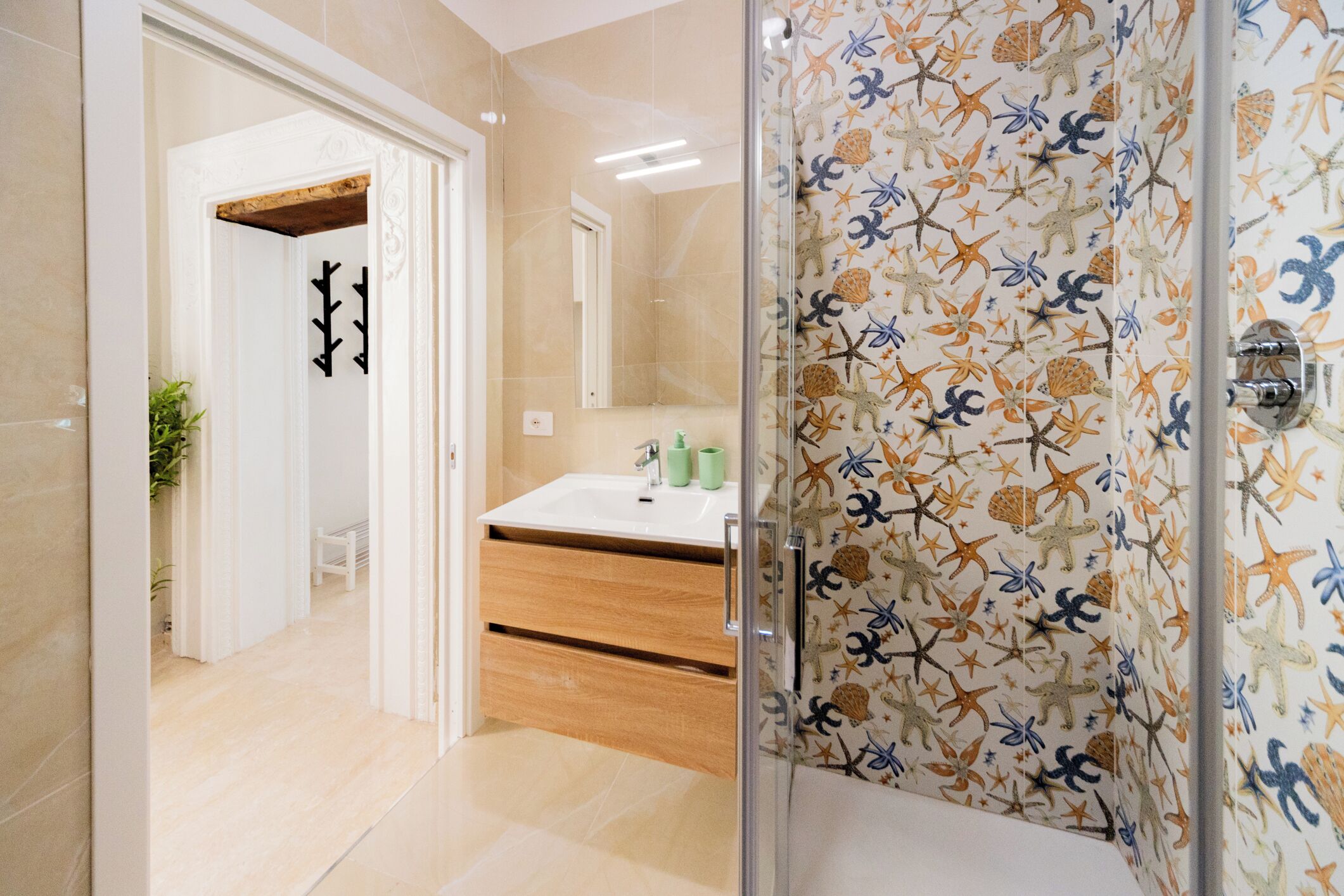 A modern bathroom with a glass shower enclosure, a sink with a mirror, and a wooden vanity.