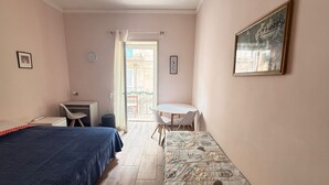 A bedroom with a bed, a desk, a chair, and a balcony with a table and chairs. - MAX-FORTUNA (Ragusa)