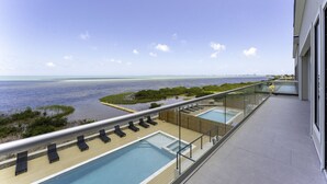 Un balcone con piscina, sedie a sdraio e vista sull'oceano.