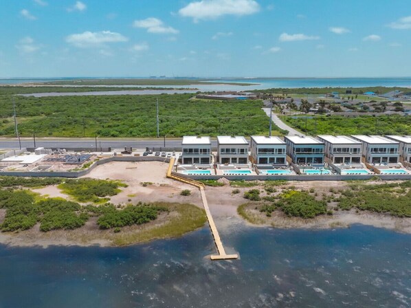 A coastal hotel with modern architecture, a dock, and a view of the sea. - 36 Spacious Way (Port Isabel)
