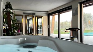 A modern bathroom with a bathtub, large windows, and a plant. - Torre Menerva Viterbo Stunning Tuscia Villa,Private Spa + Sauna + Saltwater Pool (Lazio)