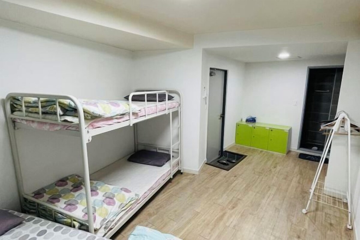 A bunk bed room with a green cabinet and a small desk.