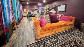 A living room with a sofa, patterned rug, and a wall with a framed picture. - GUEST HOUSE "GROOVY" PRIVATE HOT TUB ON DECK, WIFI, ROKU. (Kennard)