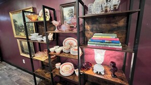 A room with a purple wall and wooden shelves displaying various items. - GUEST HOUSE "GROOVY" PRIVATE HOT TUB ON DECK, WIFI, ROKU. (Kennard)