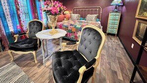 A bedroom with a bed, two chairs, a table, a lamp, and a dresser. - GUEST HOUSE "GROOVY" PRIVATE HOT TUB ON DECK, WIFI, ROKU. (Kennard)