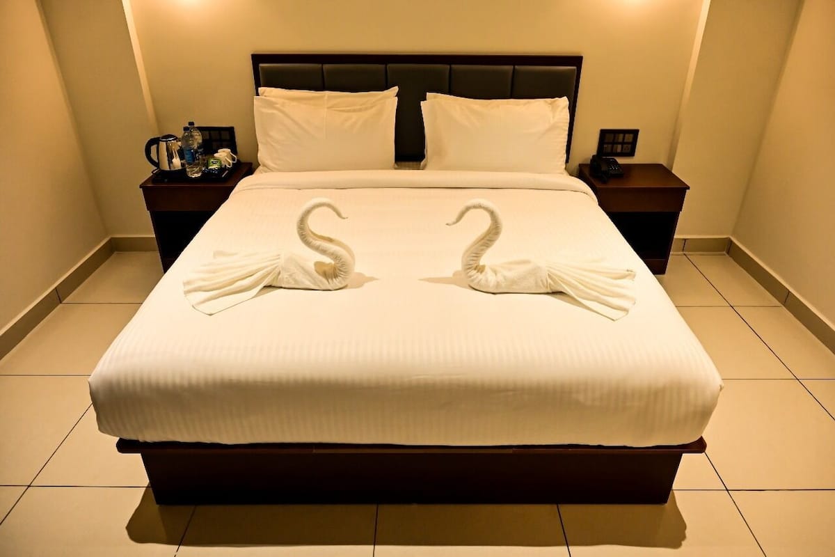 A hotel room with a large bed, two nightstands, and a headboard.