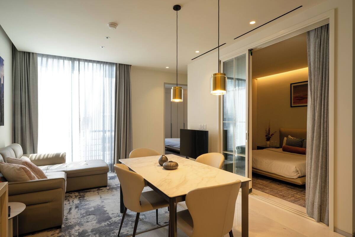 Ein modernes Hotelzimmer mit Essbereich, einer Couch, einem Bett und einem Fernseher.