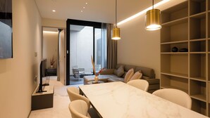 Un salon moderne avec une table à manger en marbre, des sièges confortables et une bibliothèque intégrée.