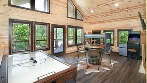 A cozy cabin with a pool table, bar area, and large windows offering views of the surrounding forest. - Smoky Ridge Hideaway: Views, Hot Tub, Game Room! (Sevierville)