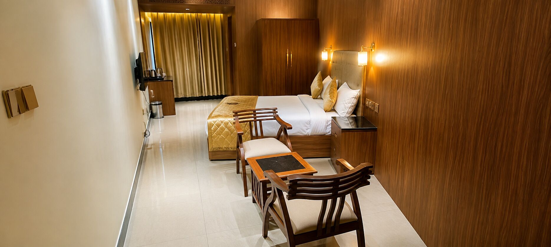 A hotel room with a bed, bedside tables, a desk, and chairs.