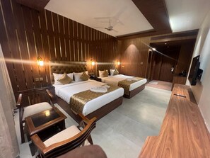 A hotel room with two beds, a desk, and a chair. - Hyders Mahal and Hotel (Thanjavur)