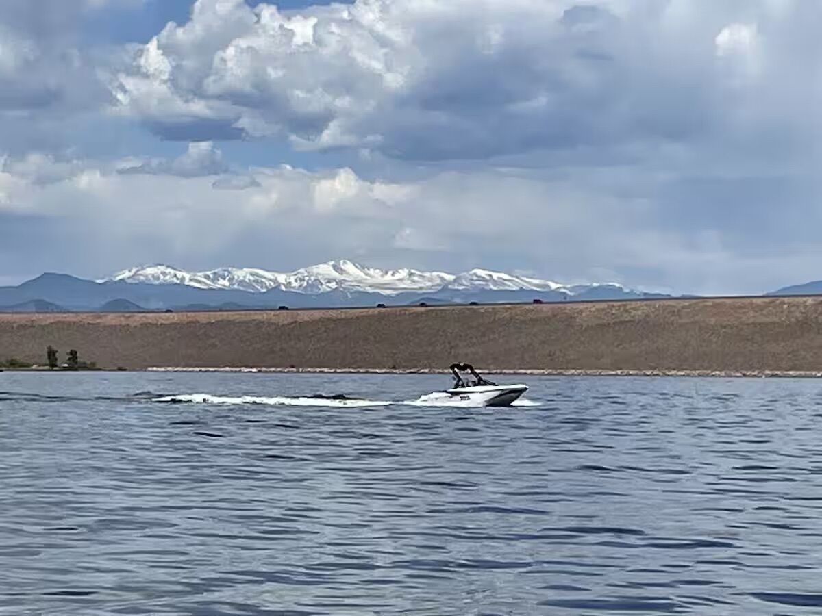 A boat on a lake with mountains in the background.