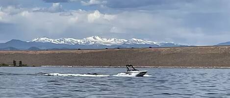 A boat on a lake with mountains in the background.