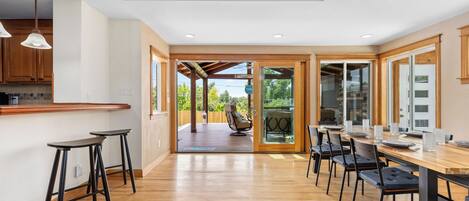 Una cocina amplia con piso de madera, una barra y una mesa de comedor para seis personas.