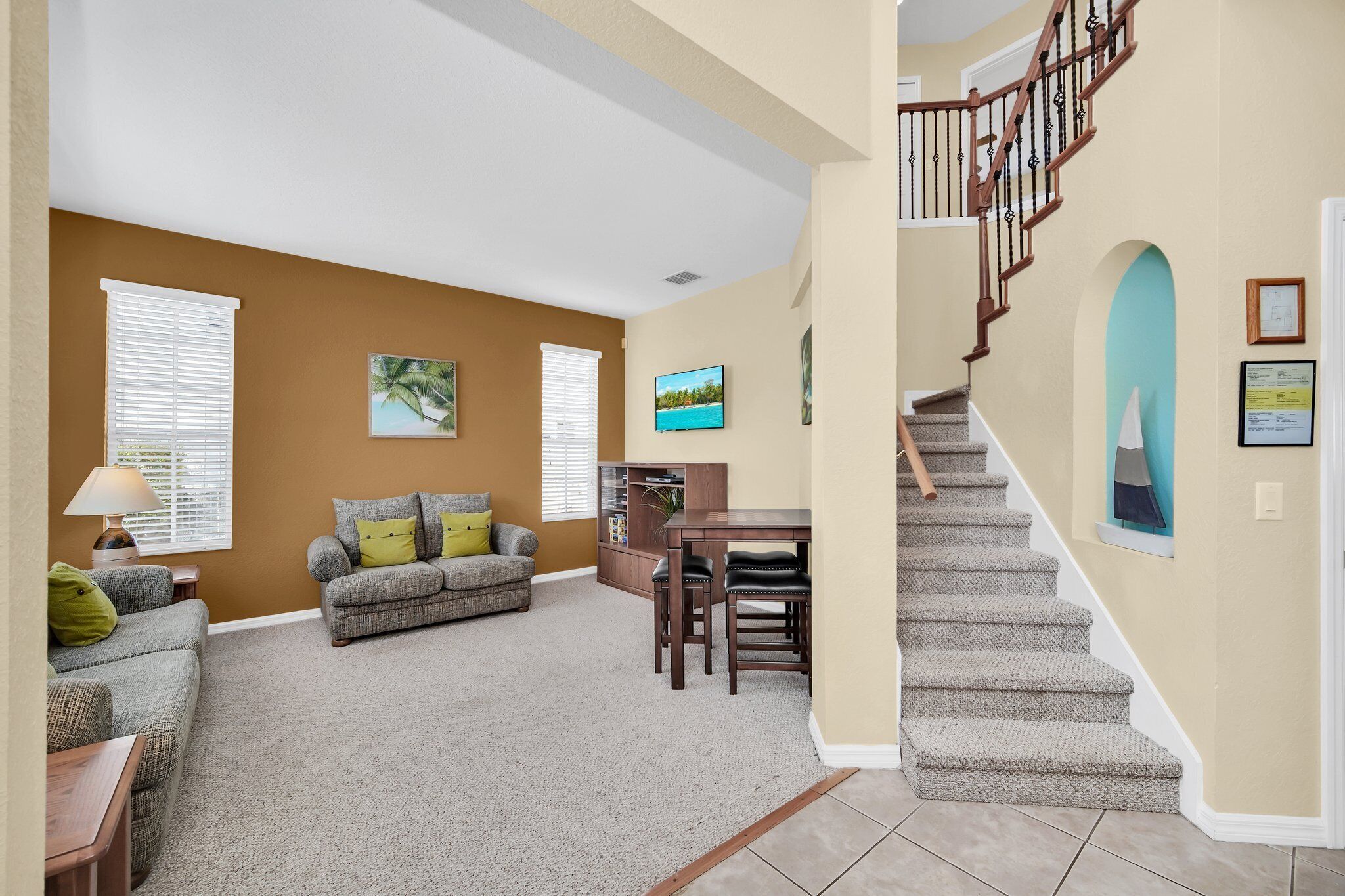 A living room with a sofa, a dining table, and a staircase.