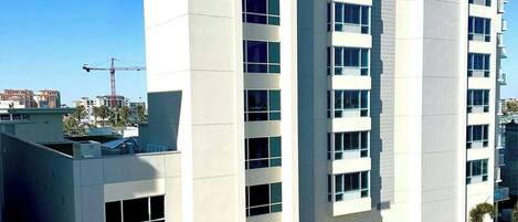 A modern multi-story building with a flat roof, large windows, and a clock on the facade.