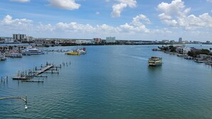 A marina with boats docked, a clear sky, and buildings in the background. - The Chart House Marina Hotel (Clearwater Beach)
