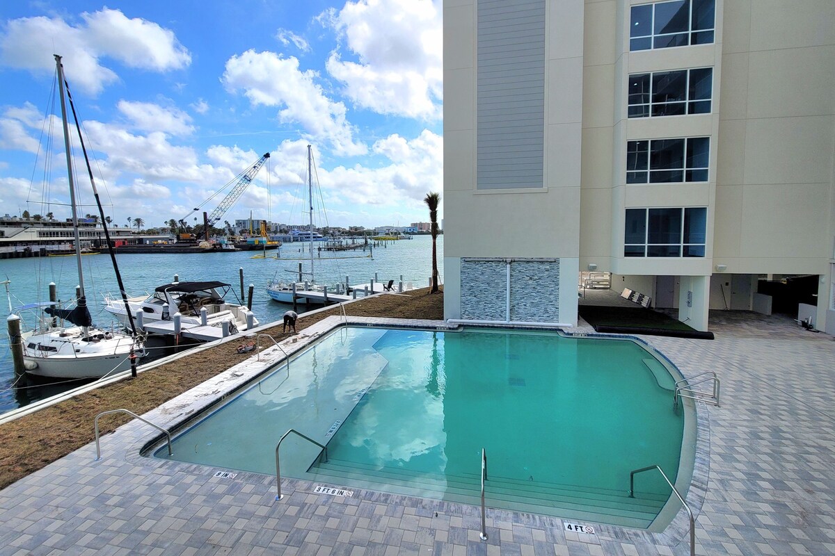 Una piscina con vistas al puerto deportivo y un edificio con numerosas ventanas.