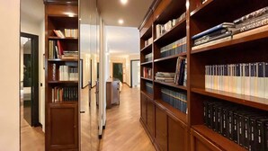 Une bibliothèque avec des étagères en bois remplies de livres et de classeurs.