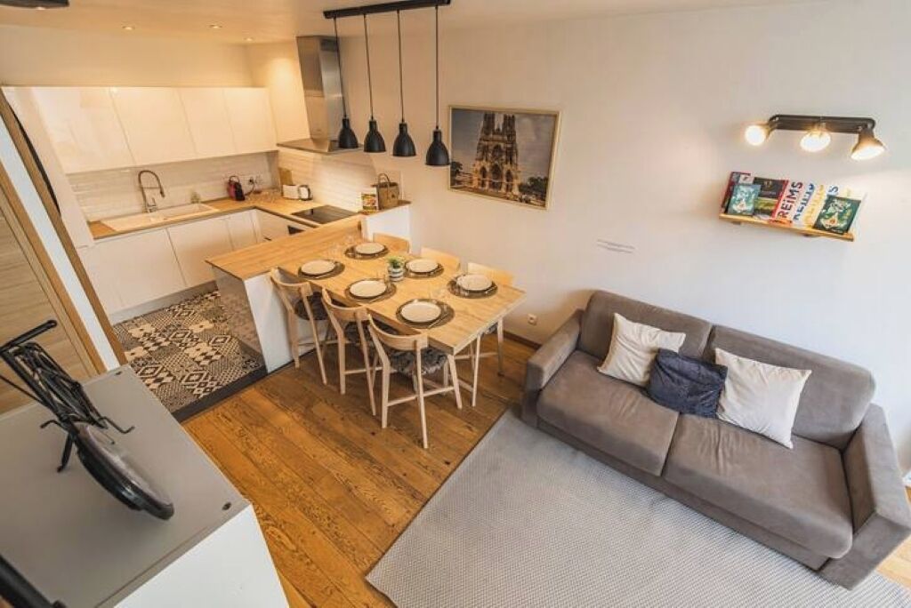 Un espacio habitable compacto con kitchenette, comedor y sofá.
