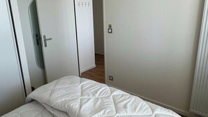 A small, single-bed room with a white mattress and a door with a lock. - Comfort Appt in a Premium Residence- Sport/cinema (Huningue)