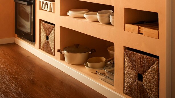 A kitchen with wooden shelves, a stove, and various kitchenware. - NEW apartment costa da Caparica - 350 meters from the beach - boho style T2 (Costa da Caparica)