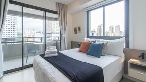 A modern hotel room with a large bed, a balcony with a view of the city, and a small table with a chair. - Cozy Near Allianz Parque Sp-p1301b (São Paulo)