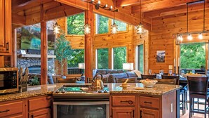 Une cuisine spacieuse dotée de plans de travail en granit, d’armoires en bois et d’un four encastré.