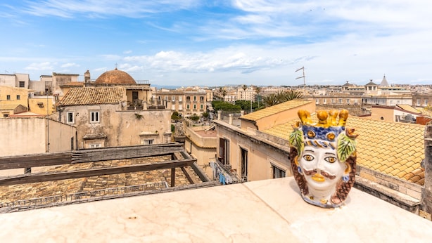 A cityscape with a prominent dome and terracotta-roofed buildings. - La Terrazza di Apollo (Syracuse)
