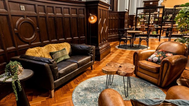 Ein gemütlicher Lounge-Bereich mit Ledersofas, einem runden Couchtisch und Holzboden.