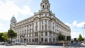 Ein großes, historisches Gebäude mit klassischer Architektur, das mehrere Kuppeln und einen markanten zentralen Turm zeigt.