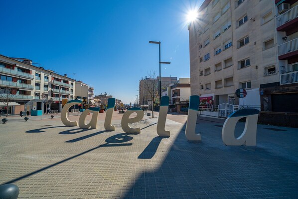 A public square with large letters spelling "Calella" and a clear blue sky. - HomeHolidaysRentals Roure - Costa Barcelona (Calella)