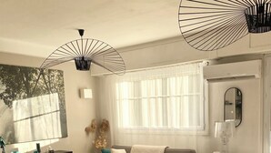 A modern living room with a sofa, coffee table, and a dog resting on a cushion. - Charming duplex apartment in town center (Corte)