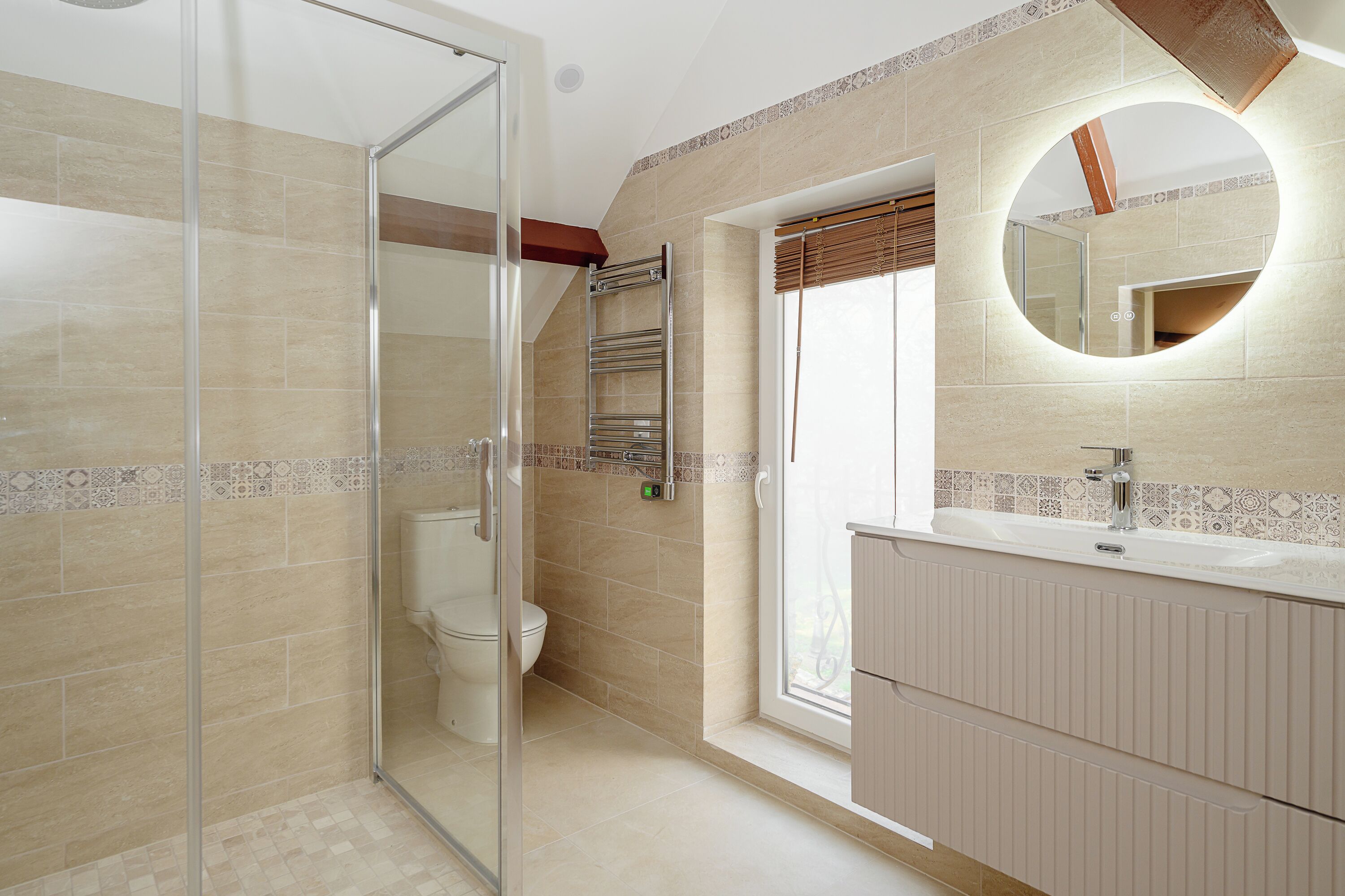 Een badkamer met een douchecabine van glas, een toilet en een wastafel met spiegel.