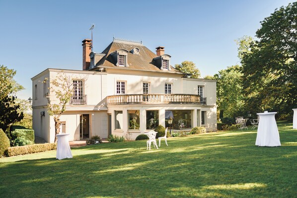 Un grand bâtiment à deux étages, doté d’une façade symétrique, de nombreuses fenêtres et d’un balcon.