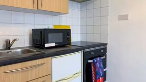 Una cocina con microondas, pileta y horno.
