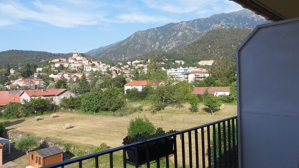 Zona residencial con casas, una iglesia y montañas al fondo.