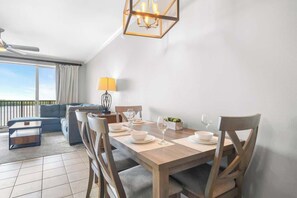 Un comedor con mesa de madera, sillas y una lámpara de araña.