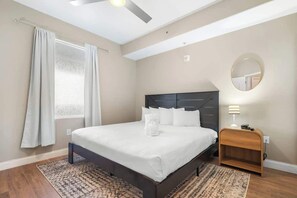 A bedroom with a bed, a nightstand, a mirror, and a ceiling fan. - Lake View-Renovated -6 Miles to Disney (Orlando)