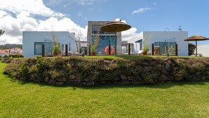 Un bâtiment moderne doté d’un mur de soutènement en pierre, de plantes en pot et d’espaces aménagés pour s  ’asseoir à l’extérieur.