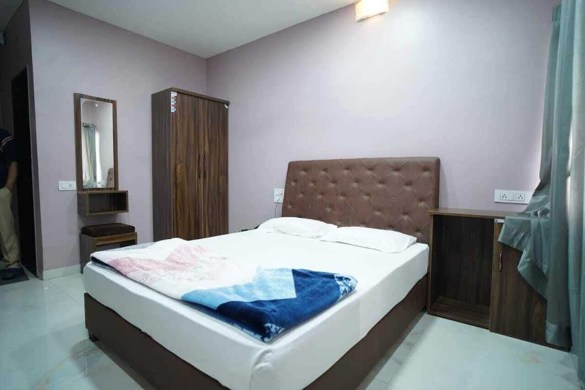 Ein Schlafzimmer mit Bett, Kleiderschrank, Spiegel und Nachttisch.