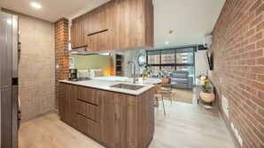 Et moderne køkken med en central ø, træskabe og en murstensvæg.