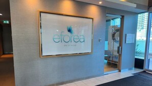 Een receptiegedeelte met een groot bord voor 'eforea SPA at Hilton' en een glazen toegangsdeur.